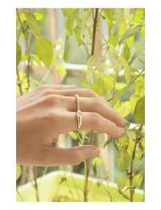 Close-up of heart-shaped zircon gold ring with pavé diamonds on finger