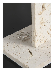 Macro shot of minimalist S925 silver double-band ring on beige stone background