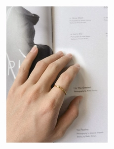 Bague minimaliste en argent S925 avec une bille dorée sur un magazine de style