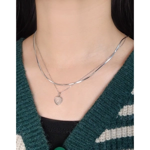 Double-layered S925 silver snake chain necklace with heart pendant on striped knitwear