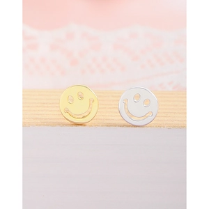 Minimalist hollow smiley face stud earrings in gold and silver finish on wood stand