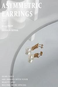 Détail de boucles d'oreilles perles asymétriques avec chaîne dorée sur miroir minimal