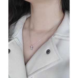Collier avec pendentif petite fleur en argent sterling 925 porté par une femme