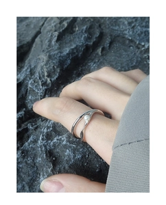 Dettaglio dell'anello in argento S925 a forma di onda con perla su sfondo di roccia grigia