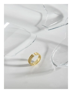 Gros plan détaillé du poinçon S925 sur une bague ajustable dorée à rayures épurées