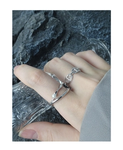 Dettaglio di un anello a doppio strato in argento S925 con catena e perla sul dito