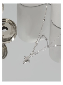 Macro shot of S925 sterling silver star pendant necklace with delicate beaded chain