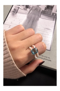 Detail of S925 silver ring featuring blue zircon and double rows of white pearls