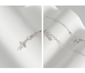 Detail of S925 sterling silver star pendant with bead chain on white background