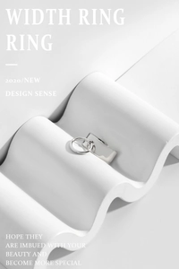 Detail of a wide silver S925 sterling silver ring with a hanging movable circular buckle