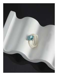 Macro detail of S925 silver ring featuring blue zircon and double-layer pearls
