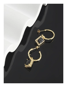 Detail von goldenen Creolen mit Bambustextur, schwarzen Edelsteinen und kleinen Diamanten
