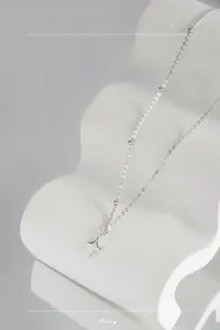 Detail of S925 sterling silver necklace with star pendant on white display stand