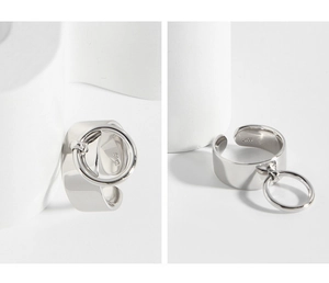 Macro view of S925 sterling silver wide band ring with a dangling mobile circle charm