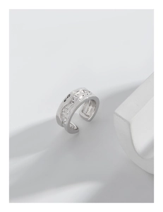 Detail of silver wavy ear cuff with irregular texture and liquid metal aesthetic