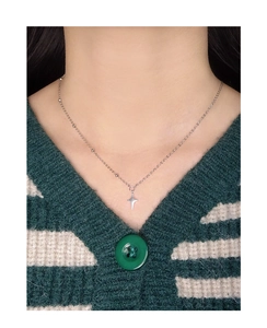 Close-up of S925 silver star pendant with beaded chain on green textured sweater