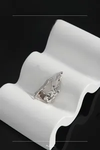 Macro detail of S925 sterling silver ring with liquid metal texture on white stand