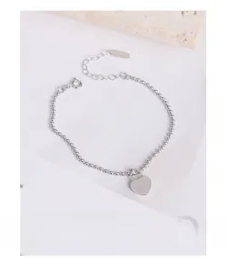 Macro detail of S925 sterling silver beaded bracelet with heart lock charm and hallmark