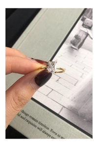 Dettaglio di un anello dorato con zircone taglio quadrato e castone a quattro griffe