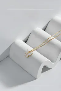 Détail du collier papillon en argent S925 avec nacre blanche sur présentoir ondulé