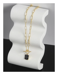 Detail of gold chunky chain necklace with toggle clasp and large black rectangular pendant