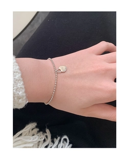 Close-up of S925 sterling silver beaded bracelet with heart padlock charm on wrist