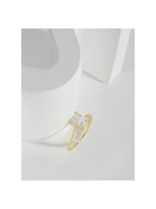 Dettaglio macro dell'anello dorato con cristallo quadrato e castone a quattro griffe