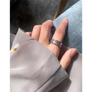 Irregular textured silver ring with an artistic molten lava design shown on a finger