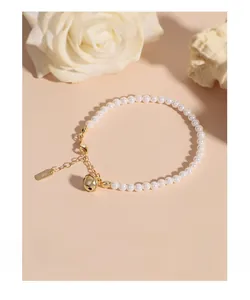 Détail macro du poinçon S925 sur un bracelet en perles avec breloque cloche dorée