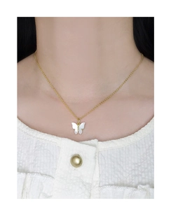 Gros plan détaillé d'un collier papillon en argent S925 avec pendentif en nacre blanche