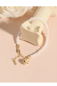 Vue macro du bracelet en perles argent S925 avec breloque cloche sur colonne romaine