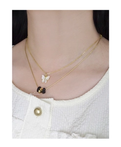 Gros plan du collier étagé en argent S925 plaqué or avec pendentif papillon en jade blanc