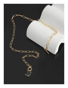 Close-up of a gold paperclip chain necklace with a black rectangular stone and toggle clasp