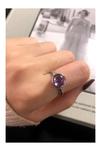 Close-up of S925 silver ring with purple zircon stone worn on finger for detail view