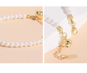 Détail macro du bracelet en perles avec cloche en argent S925 et fermoir mousqueton