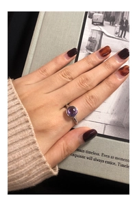 Close-up of S925 silver ring featuring a round purple zircon in a bezel setting