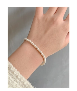 Détail du bracelet en perles d'argent S925 minimaliste avec petites perles blanches au poignet