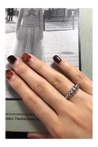 Detail of minimalist S925 sterling silver croissant ring on a model hand with magazine backdrop