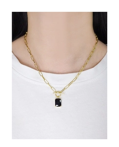 Detail of a square black gemstone pendant with a sparkling bar on a gold paperclip chain