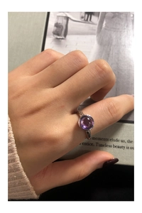 Close-up of a sterling silver ring with irregular texture and round purple zircon stone