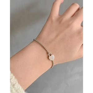 Minimalist S925 sterling silver beaded bracelet with heart lock charm on female wrist