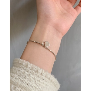 S925 sterling silver beaded bracelet featuring a polished heart lock pendant on a woman's wrist