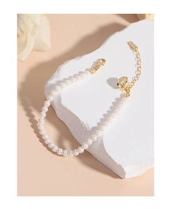 Détail du poinçon S925 et de la petite cloche dorée sur le bracelet en perles