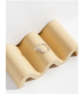 Detail of S925 sterling silver chain ring with cursive Kiss letter design on wavy pedestal