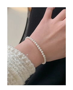 Gros plan d'un élégant bracelet en perles en argent sterling S925 sur un poignet de femme