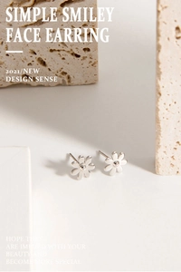 Close-up of minimalist S925 sterling silver daisy stud earrings on stone texture