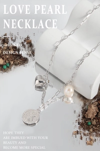 Détail du collier à trombones argenté avec pendentifs cœur, perle et pièce