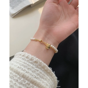 Élégant bracelet double couche en argent S925 avec perles et clochette dorée sur le poignet