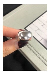 Close-up of a wide polished S925 sterling silver minimalist ring with a glossy finish