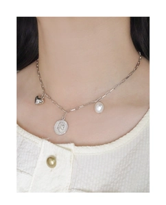 Détail du collier en argent S925 avec charms cœur, pièce et perle baroque au cou